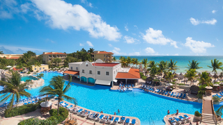 Piscina al lado del edificio del resort con balcones