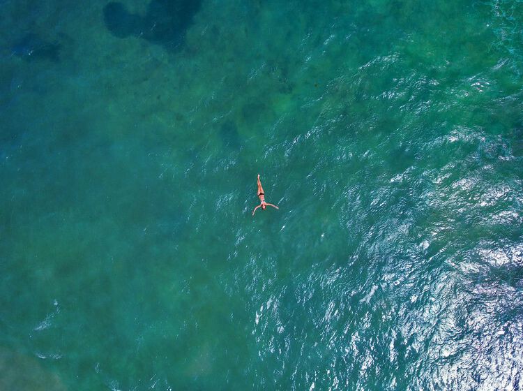 Una mujer nadando en las aguas cristalinas del Caribe